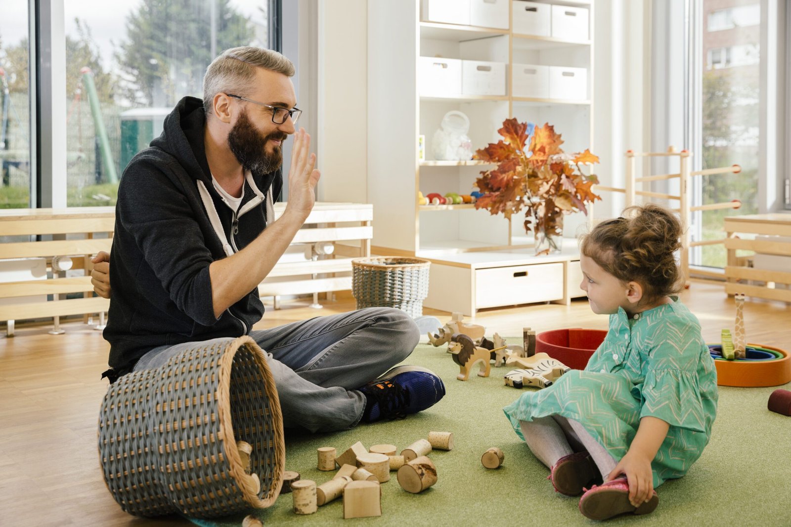 Pre-school teacher playing with girl in kindergarten, ABA therapy
